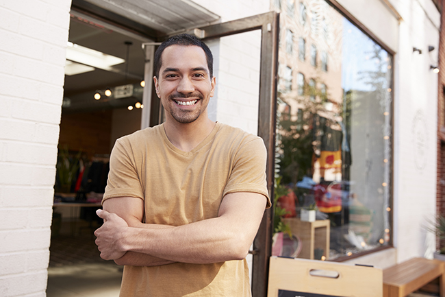 Young Hispanic shop owner smiling to camera